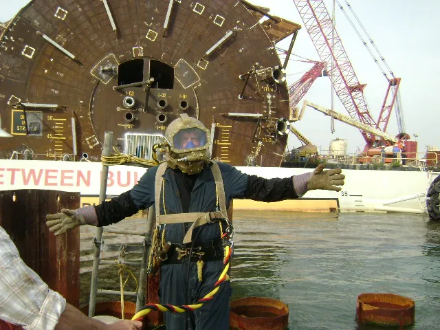 Commercial diver in a cast silicon bronze Gladiator diving helmet, working in front of a tunnel boring machine